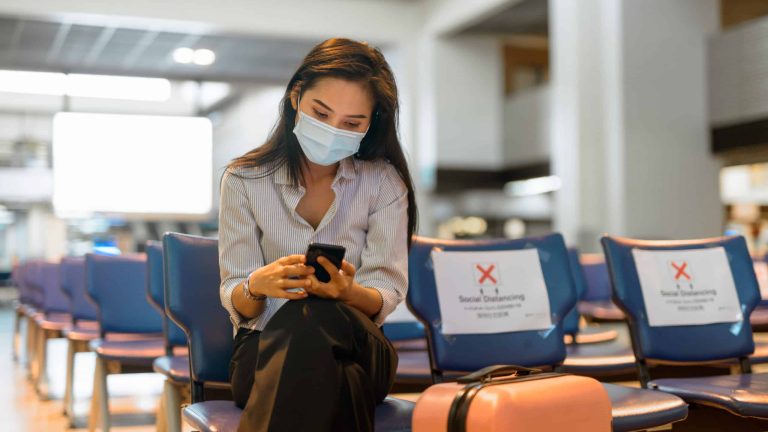 young-asian-tourist-woman-with-mask-using-phone-an-C43TS2R